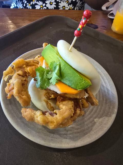 Cuisine featuring various garnishes and fried elements on a plate.
