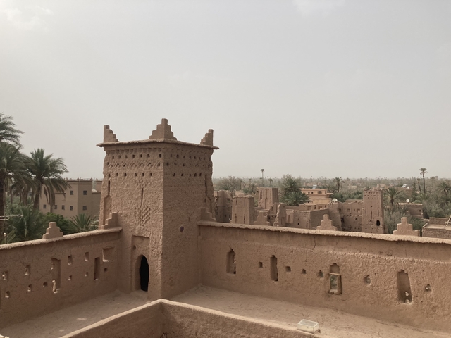       Clay buildings with a view of a desert city.
  