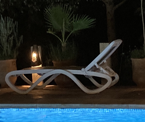       Outdoor seating area at night with a lounge chair.
  