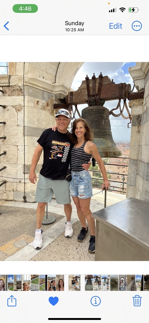       Couple posing near a large bell tower.
  