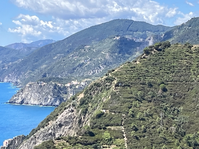       View of mountainous coastline with rocky cliffs and the sea.
  