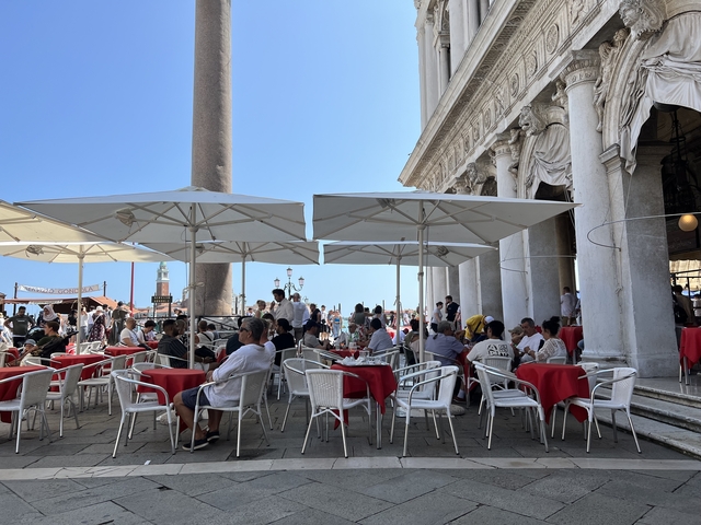       Outdoor café with people sitting under umbrellas.
  
