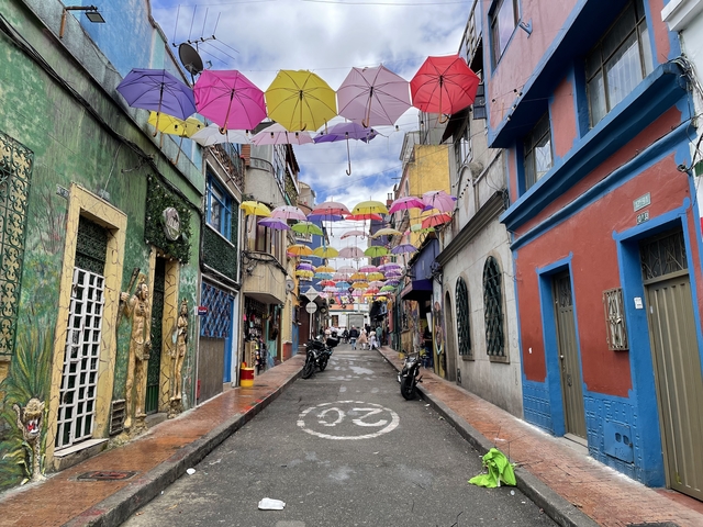       Narrow street with overhead colorful umbrellas
  