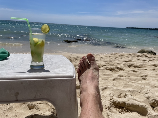       Beach scene with a foot and lime drink
  