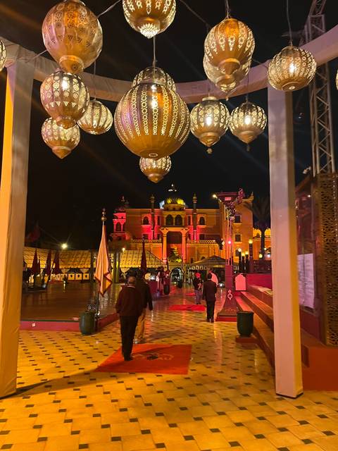 Night scene with decorative lamps and people in traditional setting.
