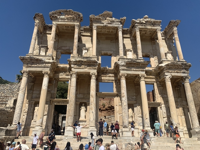       Facade of the Celsus Library in Ephesus with tourists.
  