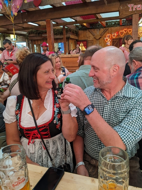 Couple toasting small bottles at a festival.