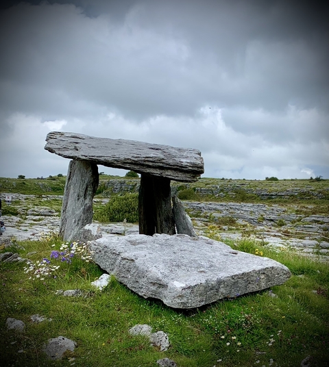 Ancient stone structure in grassy landscape.