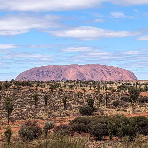       View of a large rock formation and arid landscape.
  