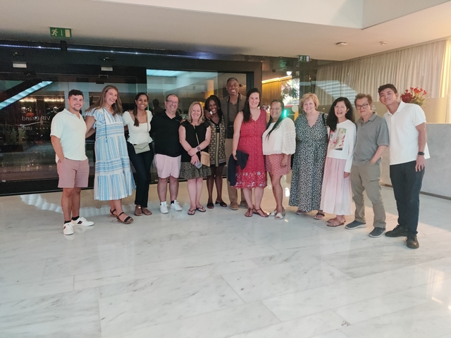       Group of people posing in a hotel lobby.
  