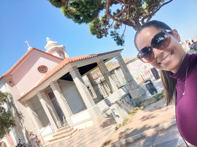       Woman smiling in front of a small chapel.
  
