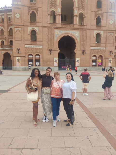 Four women posing outside a historic building.