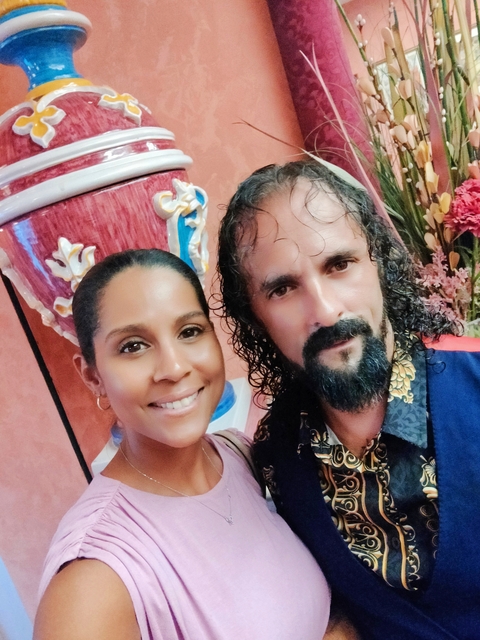 Woman taking a selfie with a man in a decorated interior.