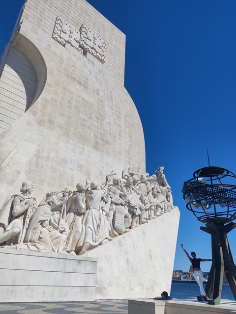       Monument with statues under a clear blue sky.
  