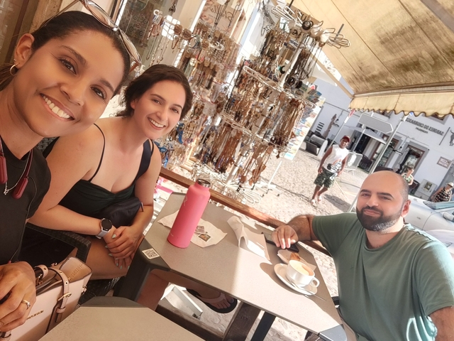       Friends sitting at an outdoor café, enjoying drinks.
  