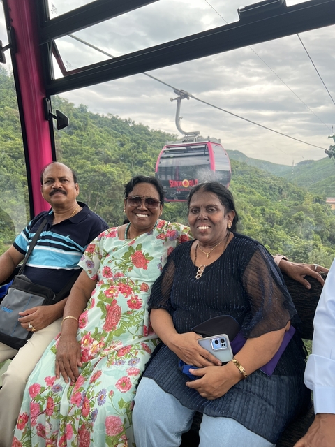 Three people smiling on a cable car ride with a scenic view.