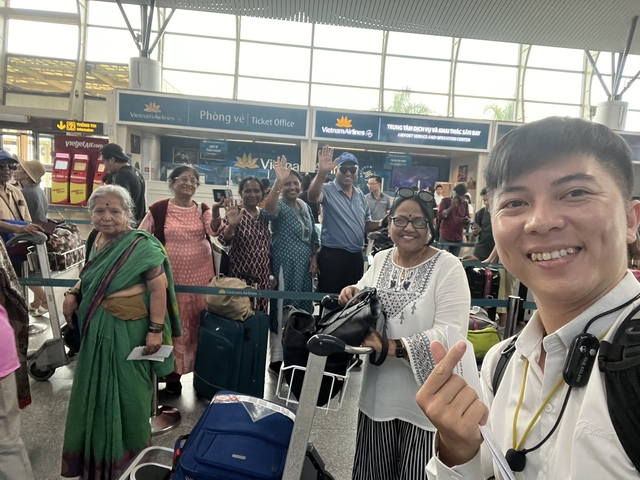 Group of cheerful people in an airport terminal near a ticket office.