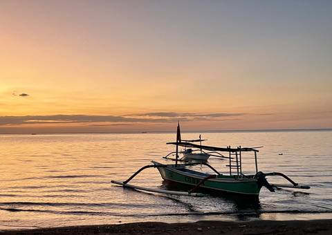       Boat on the water during a colorful sunset.
  