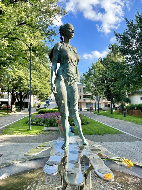       Statue of a woman in a park.
  
