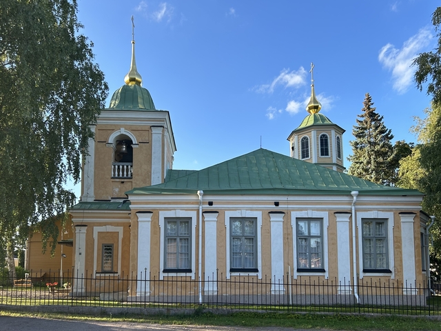       Yellow church with golden domes and blue sky.
  