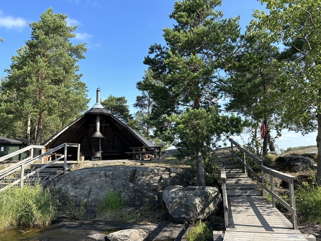       Wooden shelter with a path and surrounding trees.
  