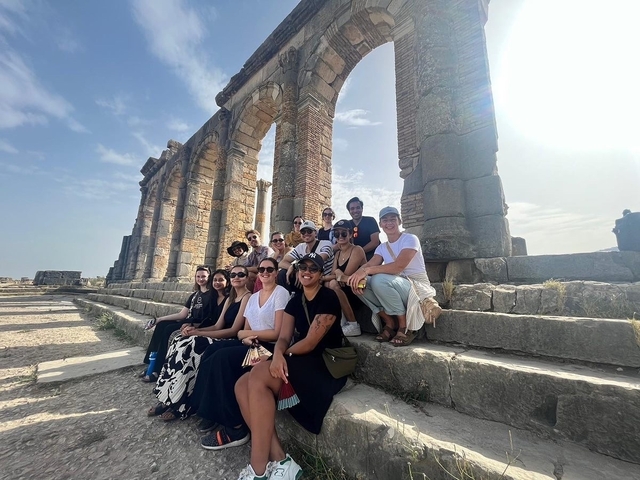 Group of people posing near ancient ruins.