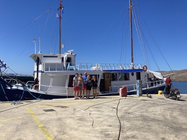       Group of people posing in front of a boat.
  