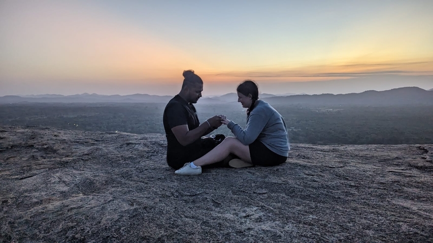 Couple seated on a rock at dusk.