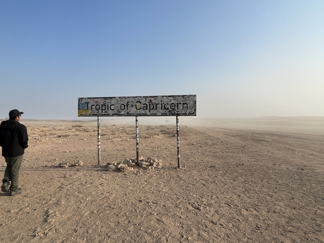 Person standing by the Tropic of Capricorn sign.