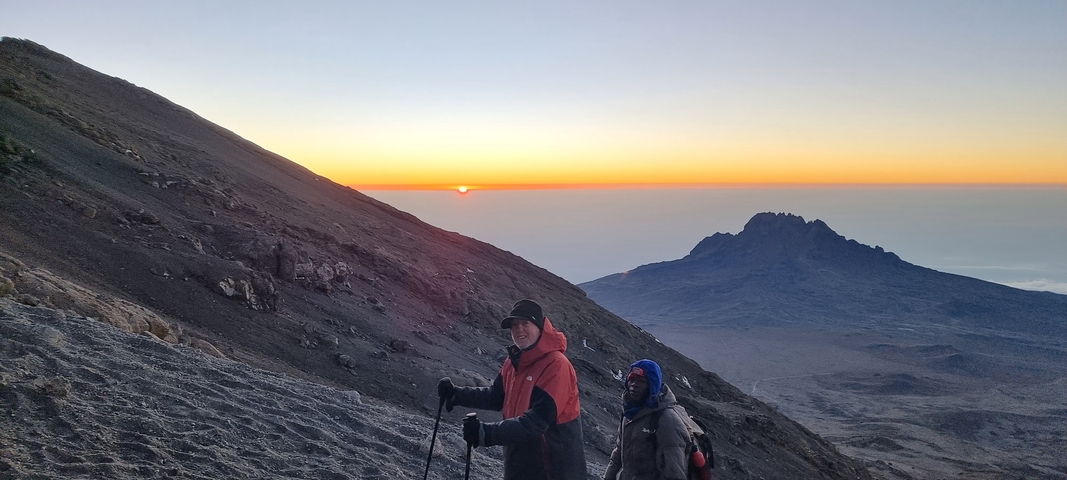 Hikers enjoying a sunrise view from a mountain.