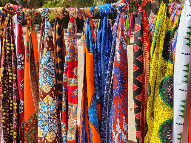       Vibrant, patterned fabric hanging on display.
  