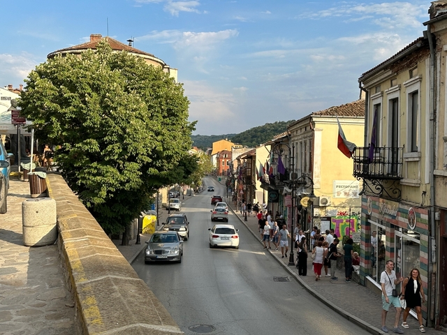 Busy street with shops and people walking by.