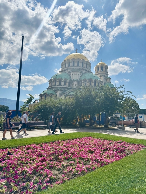 A large cathedral with people walking nearby.