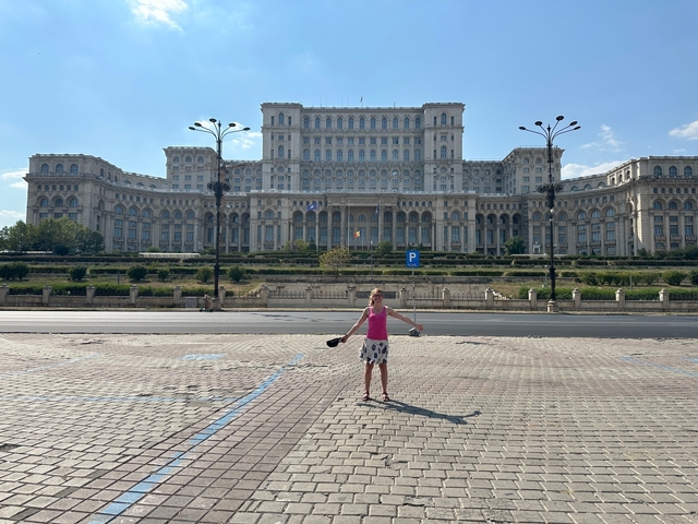 Person posing in front of a large governmental building.