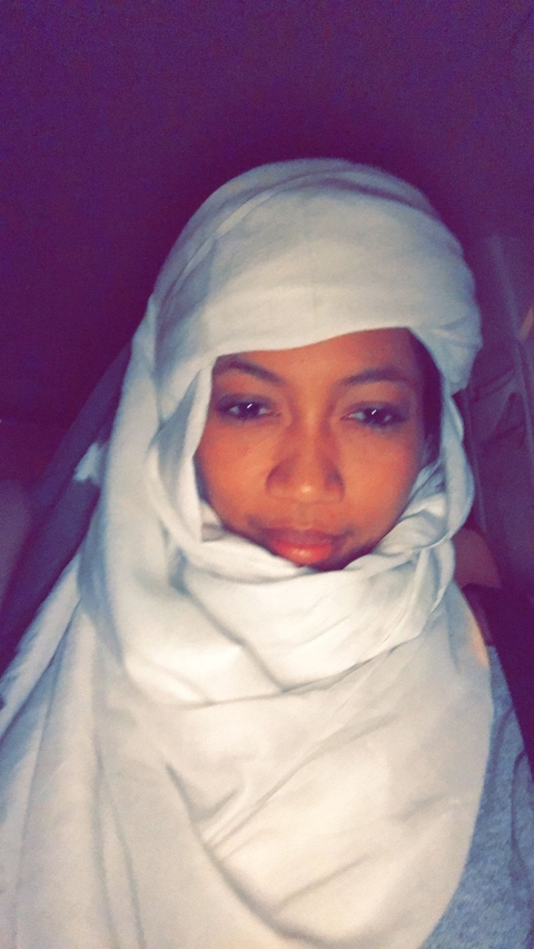       Close-up portrait of a person with a white headscarf.
  