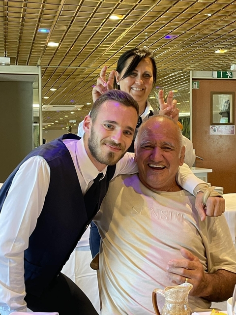 Two men smiling together indoors.
