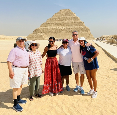       Group of people smiling in front of an ancient pyramid.
  