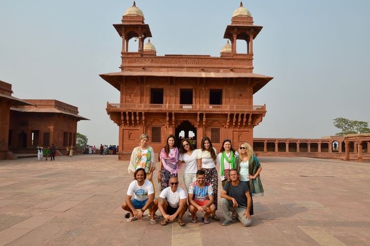 Group with an ancient red sandstone building in the background.