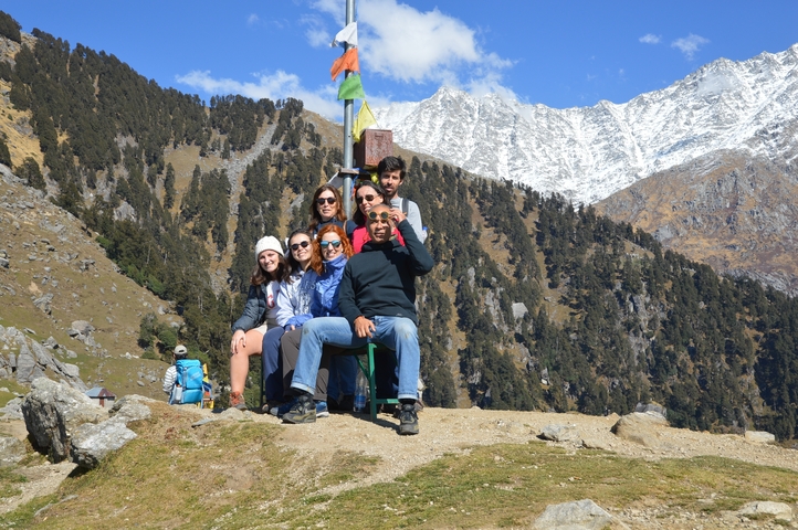 Group seated in front of a snow-capped mountain range.