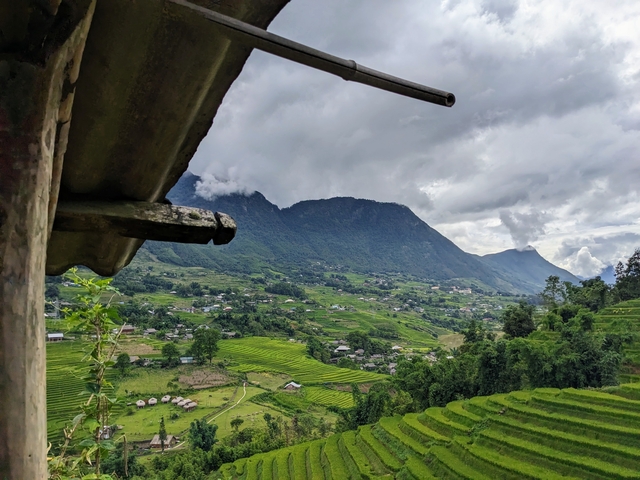 Scenic view of rice terraces and mountains under cloudy sky.
