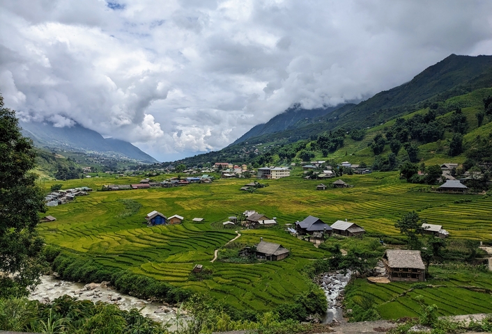       Expansive landscape view with rice paddies and mountains.
  