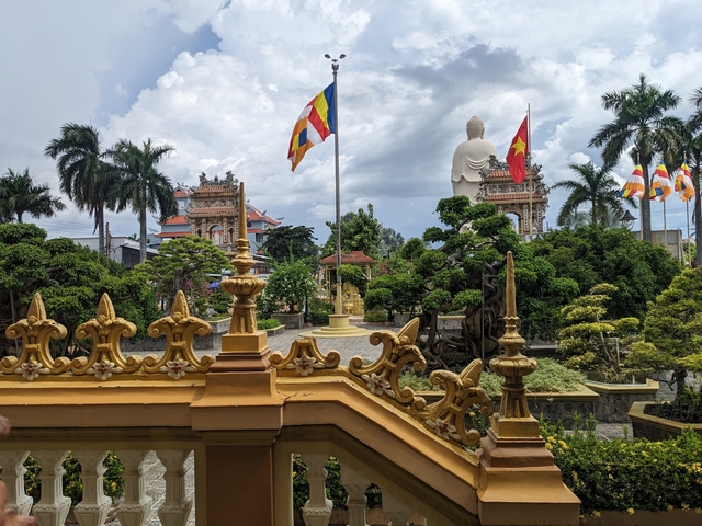       Temple gardens with statues and flags, an elegant setting.
  