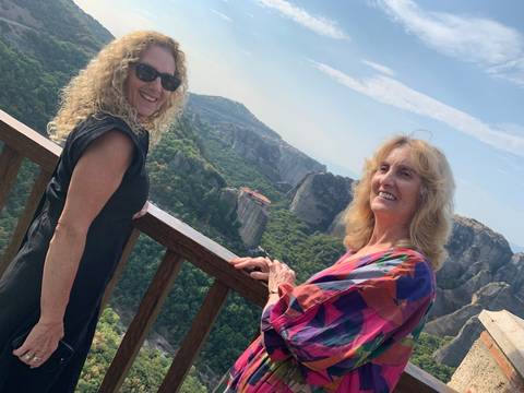       Two people enjoying a view of a mountainous landscape.
  