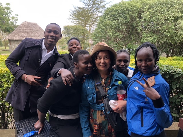 Group of people smiling together in a garden setting.