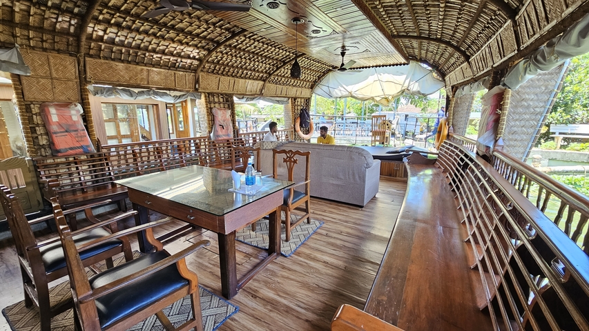 Interior of a houseboat with seating and scenic views outside.