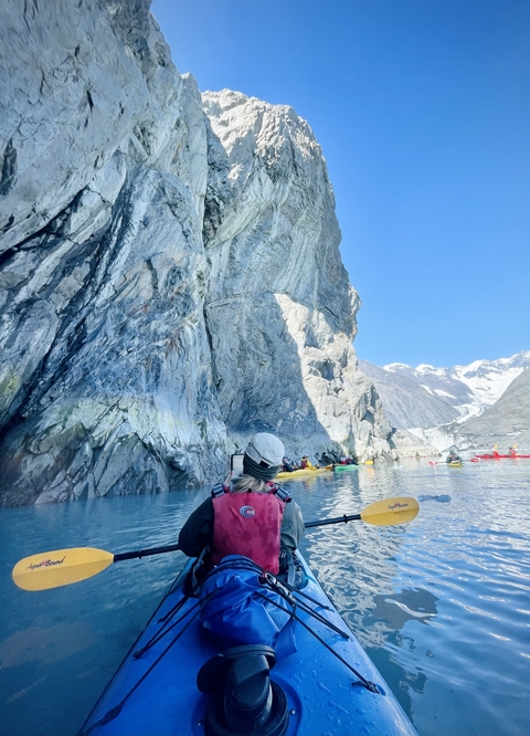       Kayaking near a rocky glacier
  