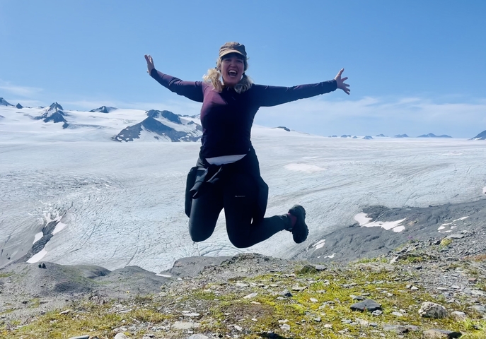       Person jumping with a glacier in the background
  