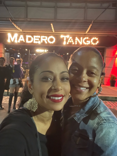 Two women at night with bright lights in the background