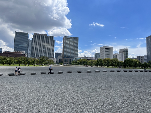       Skyline of modern city buildings with people in the foreground.
  