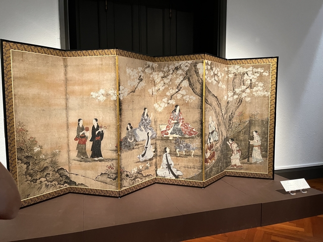       A traditional Japanese folding screen with painted figures.
  